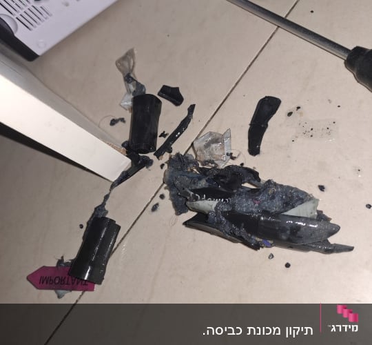 חלקים שבורים של מכשיר חשמלי וכלי עבודה על הרצפה